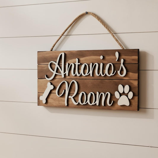 Personalized pet name wood sign with raised 3D lettering, paw prints and a bone, hung with natural jute twine