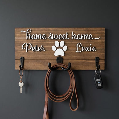 Home sweet home wood key and leash holder with 3D names around a raised white paw and black metal wall hooks