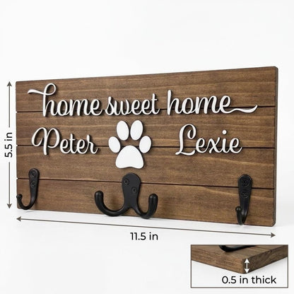 Home sweet home wood key and leash holder with 3D names around a raised white paw and black metal wall hooks