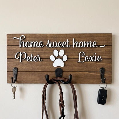 Home sweet home wood key and leash holder with 3D names around a raised white paw and black metal wall hooks