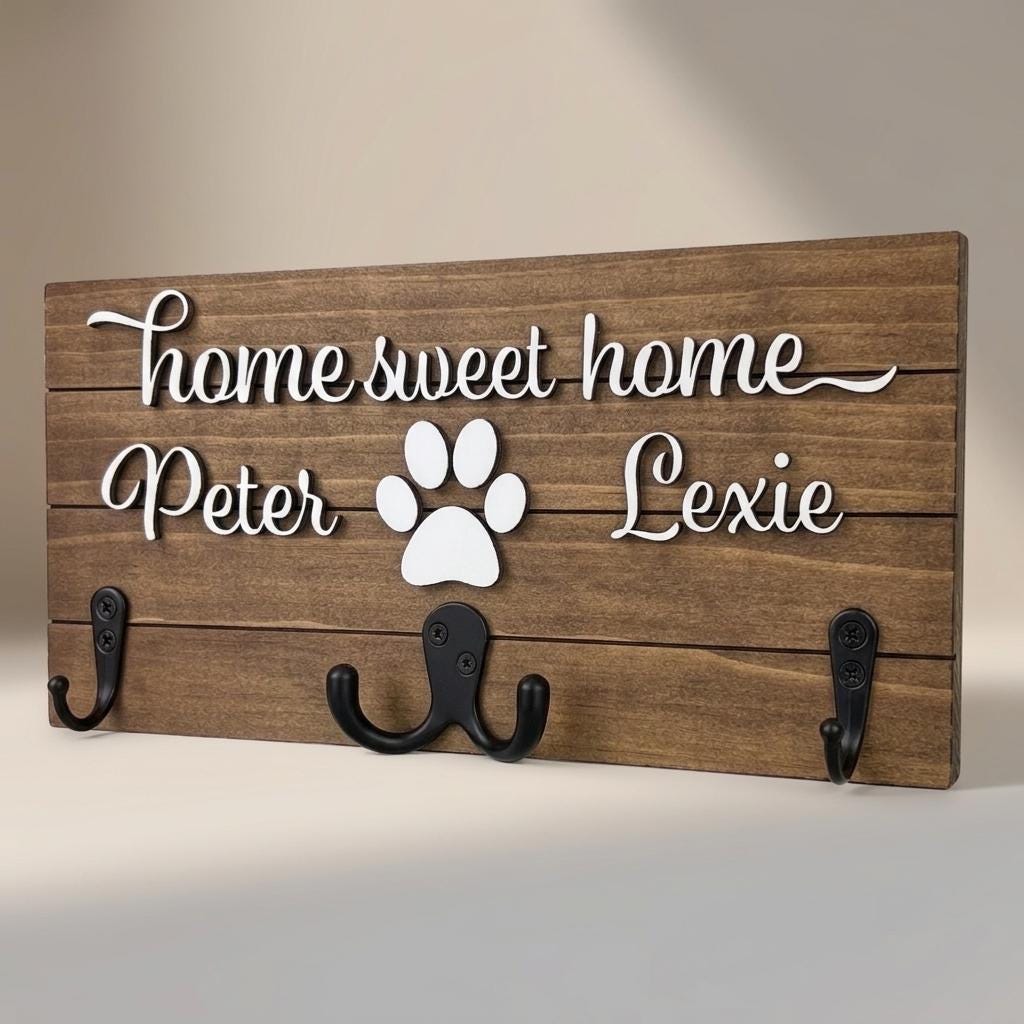 Home sweet home wood key and leash holder with 3D names around a raised white paw and black metal wall hooks
